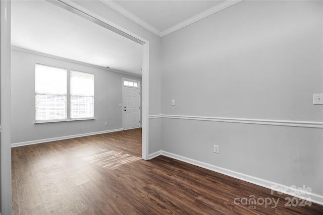 empty room featuring dark hardwood / wood-style floors and ornamental molding