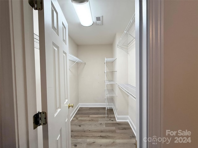 walk in closet with wood-type flooring