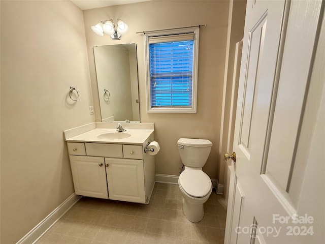 bathroom with tile patterned flooring, vanity, and toilet