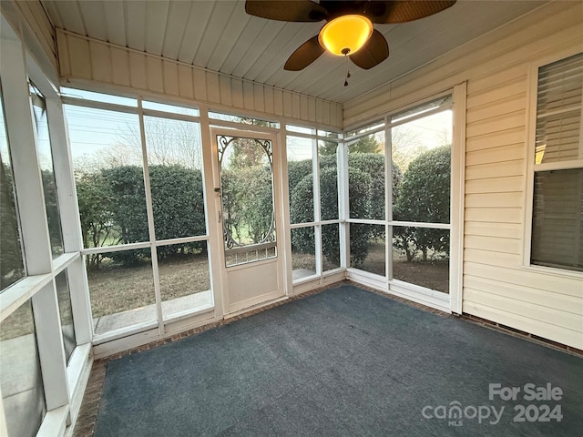 unfurnished sunroom featuring ceiling fan and wooden ceiling