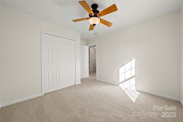 unfurnished bedroom featuring light carpet, a closet, and ceiling fan