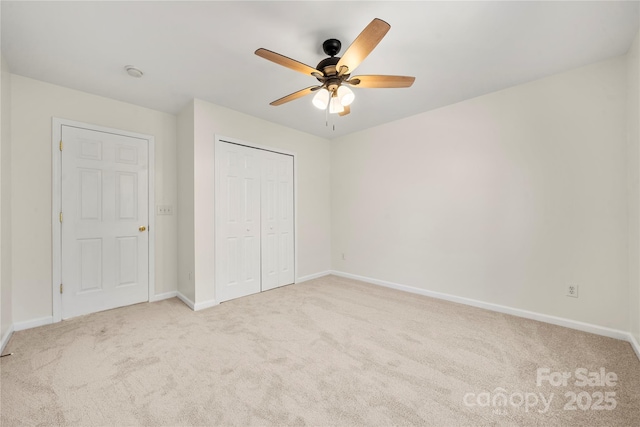 unfurnished bedroom featuring light carpet, a closet, and ceiling fan