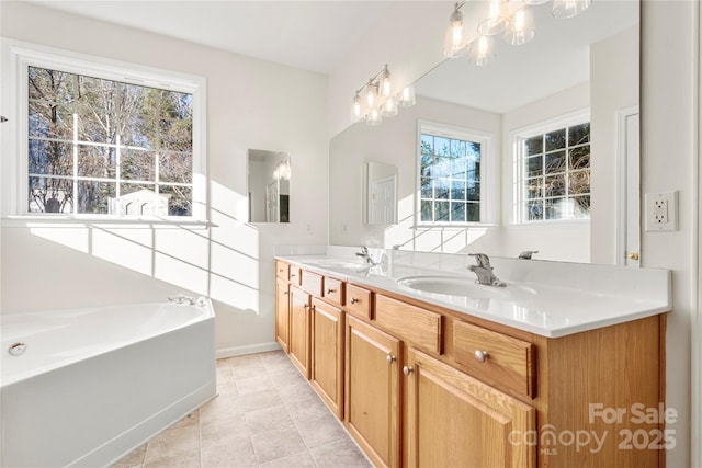 bathroom with tile patterned floors, a bathtub, vanity, and an inviting chandelier