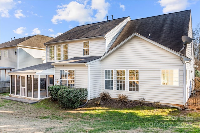 back of property with a sunroom and a yard