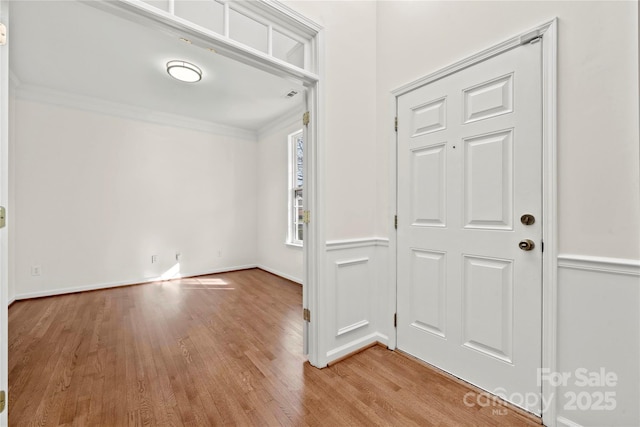 foyer entrance with hardwood / wood-style flooring and crown molding