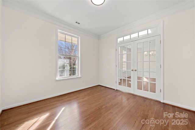 unfurnished room featuring french doors, ornamental molding, and wood-type flooring