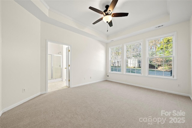 carpeted spare room featuring ceiling fan, crown molding, and a tray ceiling