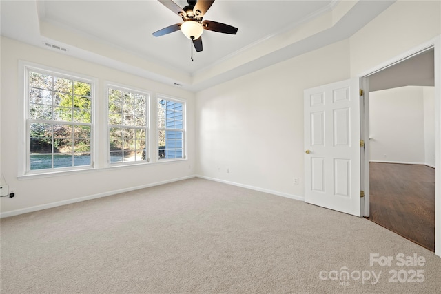 unfurnished room with carpet floors, a tray ceiling, and ceiling fan