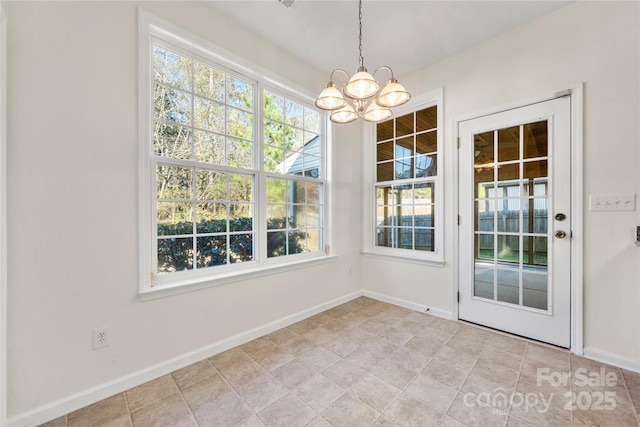 unfurnished dining area featuring a chandelier