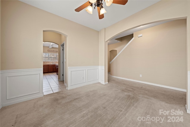 spare room featuring light carpet and ceiling fan