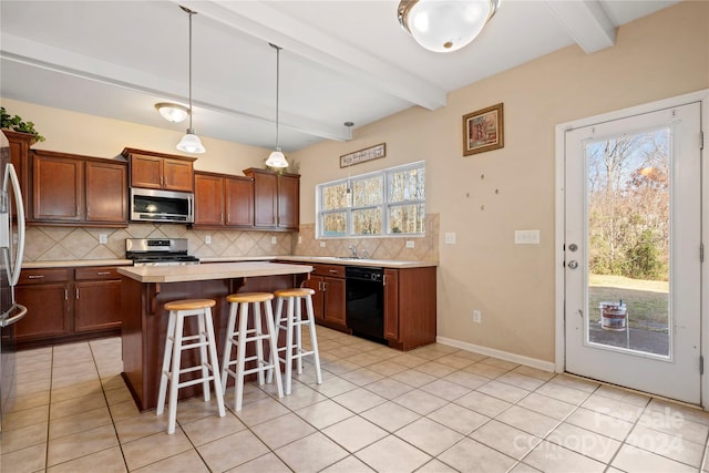 kitchen featuring beamed ceiling, a healthy amount of sunlight, a kitchen island, and stainless steel appliances