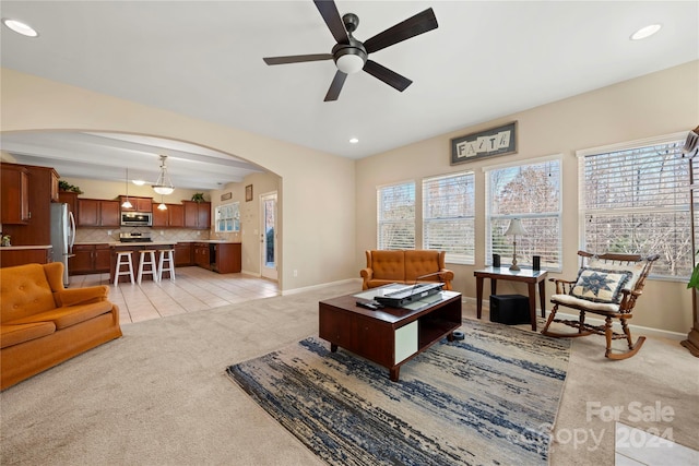 living room featuring plenty of natural light, ceiling fan, and light colored carpet