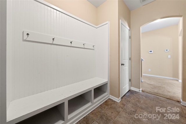 mudroom featuring dark colored carpet