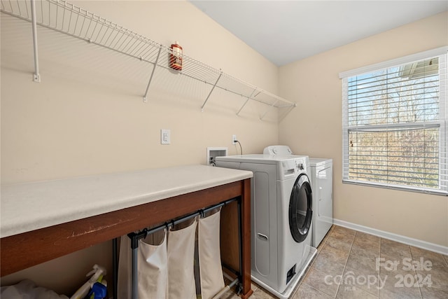 washroom with washer and dryer and light tile patterned floors