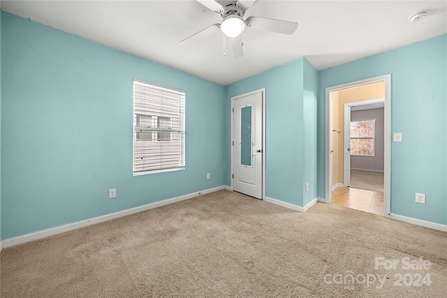 carpeted spare room with ceiling fan