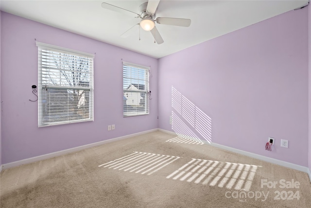 carpeted spare room featuring ceiling fan