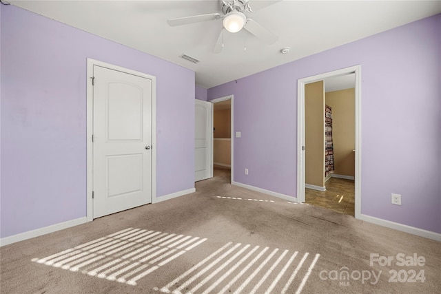 unfurnished bedroom with ceiling fan and light colored carpet