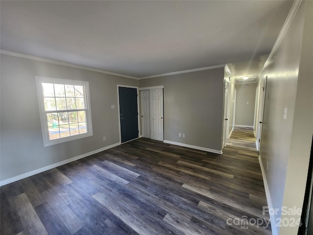 spare room with dark hardwood / wood-style flooring and crown molding