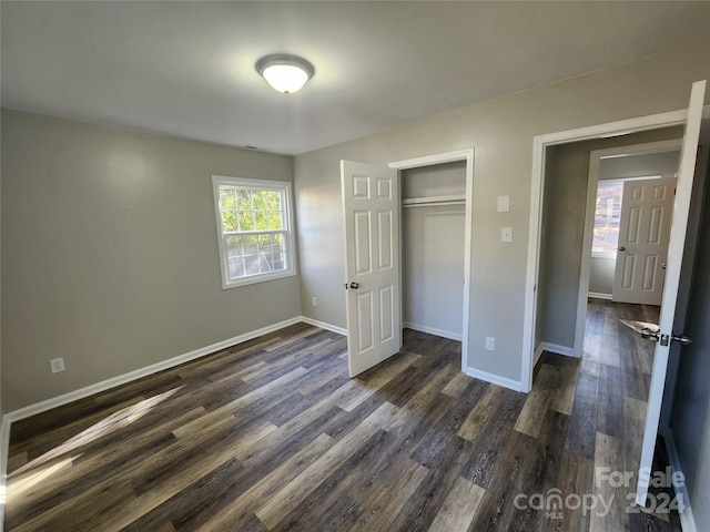 unfurnished bedroom featuring a closet and dark hardwood / wood-style floors