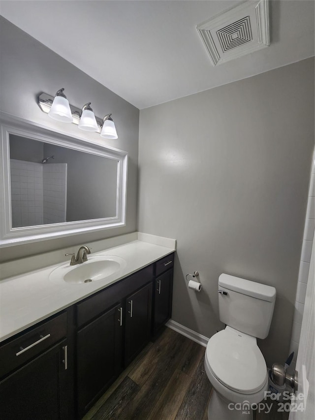 bathroom with hardwood / wood-style flooring, vanity, and toilet