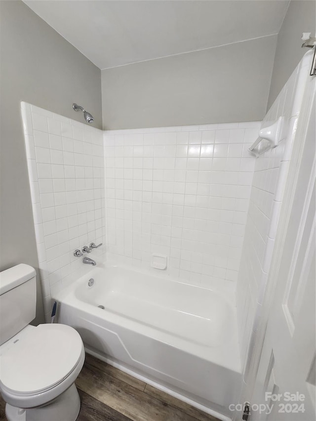 bathroom featuring toilet, tiled shower / bath, and hardwood / wood-style flooring