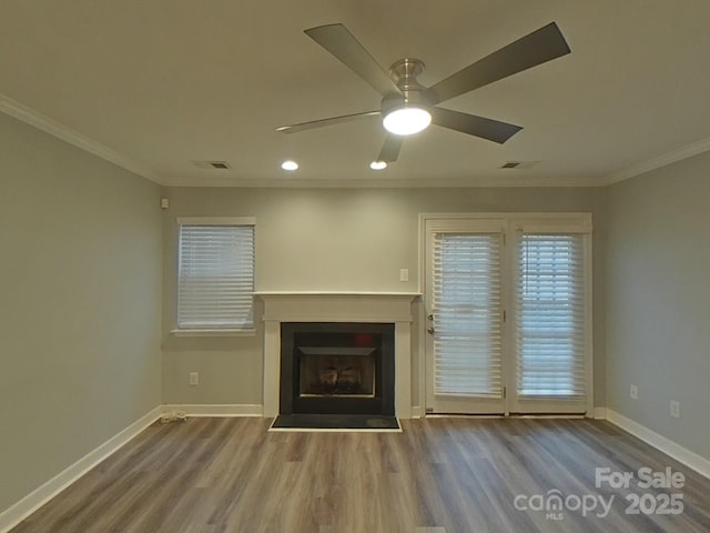 unfurnished living room with crown molding, a fireplace, baseboards, and wood finished floors