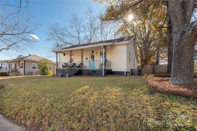 view of front of house featuring covered porch, central AC unit, and a front lawn