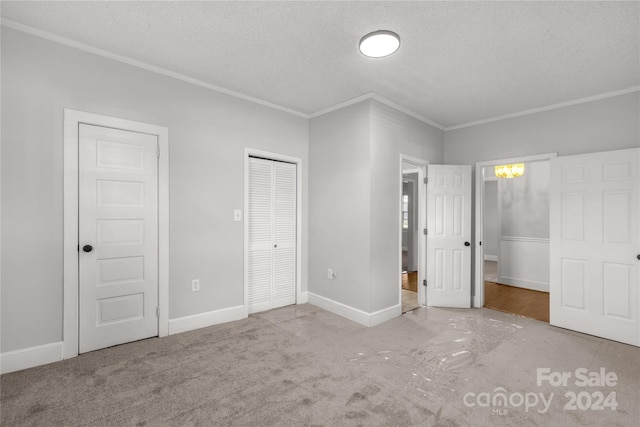 unfurnished bedroom with light carpet, a textured ceiling, and crown molding