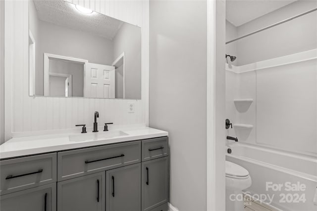 full bathroom featuring shower / bathing tub combination, vanity, a textured ceiling, and toilet