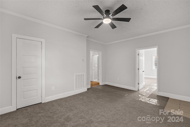 carpeted empty room featuring ceiling fan, ornamental molding, and a textured ceiling