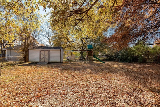 view of yard featuring a playground and a storage unit