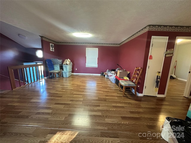 interior space with hardwood / wood-style floors, a textured ceiling, and ornamental molding