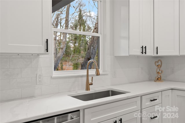 kitchen featuring dishwasher, a healthy amount of sunlight, white cabinetry, and sink