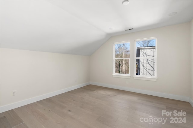 bonus room with light hardwood / wood-style floors and lofted ceiling