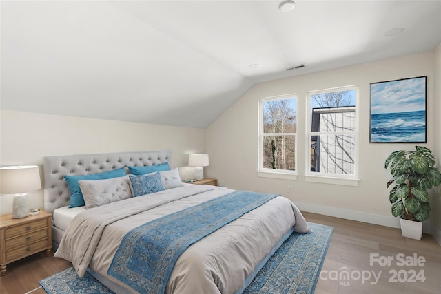 bedroom featuring hardwood / wood-style flooring and lofted ceiling