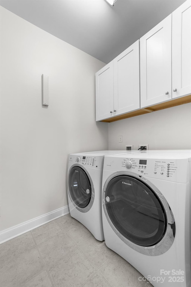 laundry area with separate washer and dryer and cabinets