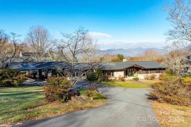 view of front facade featuring a mountain view and a front yard