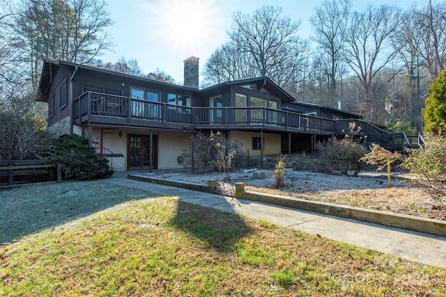 back of house featuring a yard and a deck