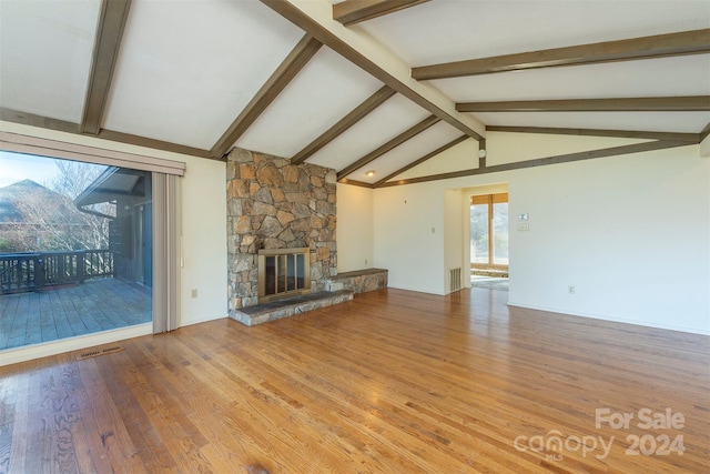 208 Dogwood Ln, Black Mountain, NC 28711 - unfurnished living room with a stone fireplace, lofted ceiling with beams, and wood-type flooring