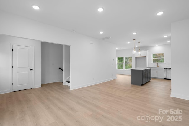 unfurnished living room with light hardwood / wood-style floors and sink