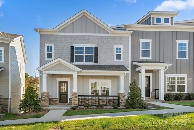 craftsman inspired home featuring board and batten siding, a porch, and stone siding