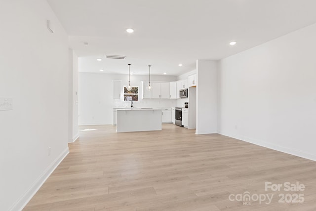 unfurnished living room with sink and light wood-type flooring