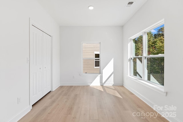 unfurnished bedroom featuring a closet and light hardwood / wood-style flooring