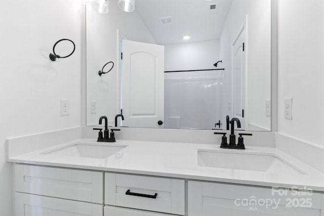 bathroom featuring walk in shower and vanity