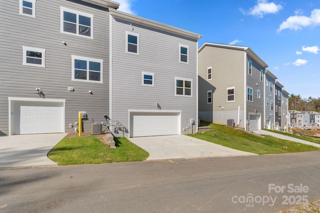 exterior space with central AC, a garage, and a yard