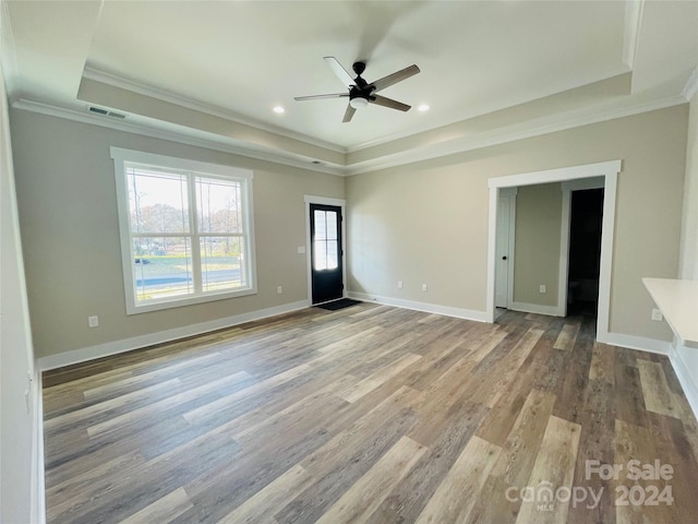 interior space featuring ceiling fan, crown molding, light hardwood / wood-style flooring, and a tray ceiling