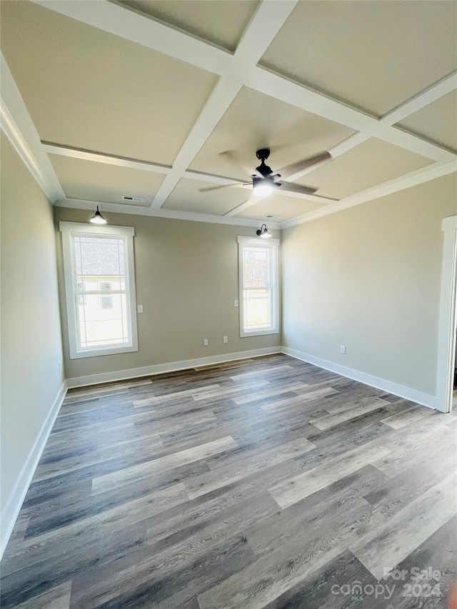 unfurnished room featuring plenty of natural light, ceiling fan, wood-type flooring, and coffered ceiling