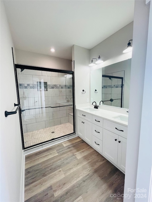 bathroom featuring vanity, an enclosed shower, and hardwood / wood-style flooring