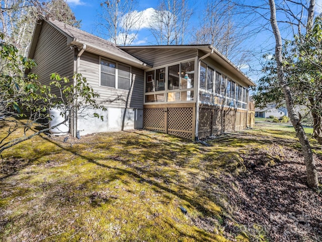 back of property with a yard and a sunroom