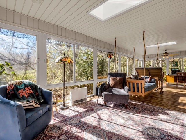 sunroom featuring ceiling fan, a healthy amount of sunlight, and a skylight